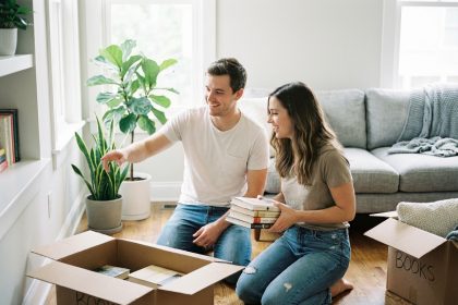 Jeune couple déballant des livres dans un salon moderne